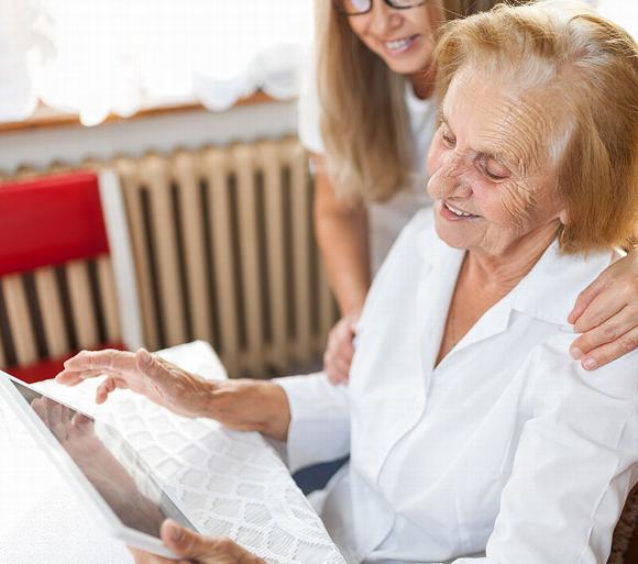 helping elderly lady to attend an online appointment